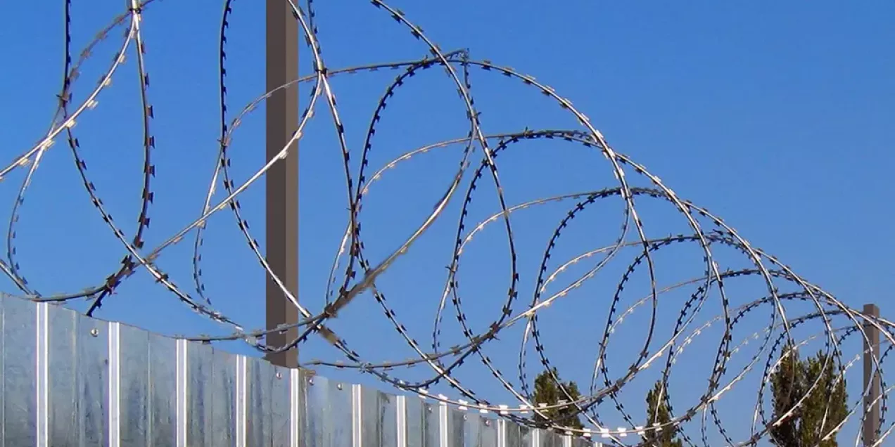 Mounting razor wire on a fence